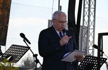 Elegancko ubrany mężczyzna przemawia do mikrofonu na scenie 