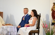 Kobieta i mężczyzna w eleganckich strojach siedzący w honorowym miejscu w kościele 