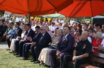 Kilkadziesiąt osób siedzących na ławkach przed sceną 