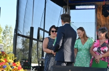 Mężczyzna podający rękę kobiecie na scenie. Wręczanie nagród. 