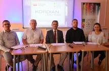 Czworo mężczyzn i kobieta siedzą przy stole 