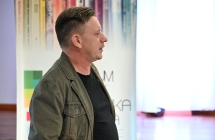 Mężczyzna na tle baneru z napisem - centrum kultury i biblioteka publiczna w malanowie 