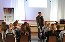 Mężczyzna podczas prelekcji. Naprzeciw niego siedzący młodzi ludzie. 2