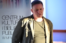 Mężczyzna na tle baneru z napisem Centrum Kultury i Biblioteka Publiczna w Malanowie 