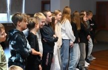 Grupa młodzieży stojąca w rzędzie i obserwująca pokazu samoobrony 