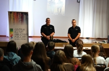 Dwoje policjantów opowiadających młodzieży zasady bezpieczeństwa 