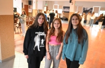 Trzy młode dziewczyny, w tle inne dzieci i młodzież 