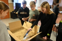 Młodzi detektywi szukający w piasku monet za pomocą wykrywacza metali 