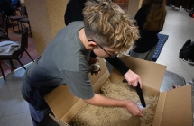 Chłopiec szukający w piasku skarbu za pomocą wykrywacza metali 