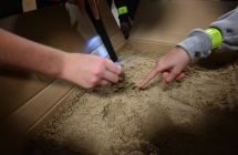 Dłonie dzieci szukających skarbu w piasku 