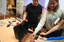 Mężczyzna częstujący dziewczynę oraz innych z wygranej grupy słodyczami 