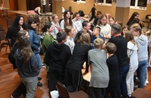 Kilkudziesięciu młodych ludzi słuchających mężczyzny 