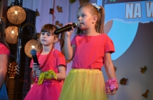 Dwie dziewczynki na scenie podczas wykonywania utworu wokalnego 