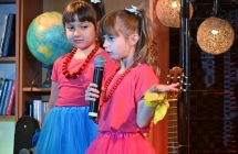 Dwie dziewczynki wykonujące utwór wokalny na scenie 