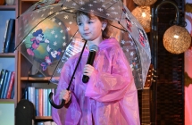 Dziewczynka trzymająca parasolkę i mikrofon 