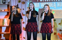 Trzy dziewczynki w jednakowych strojach podczas występu na scenie 