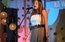 Elegancko ubrana dziewczyna wykonująca utwór wokalny 