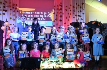 Grupa kilkunastu dzieci oraz dorosłych na scenie 