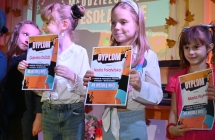 Kilka dziewczynek z dyplomami na scenie 