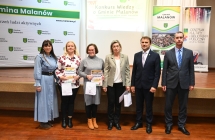 Cztery kobiety i dwoje mężczyzn stojących przed sceną 