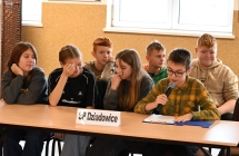Uczniowie siedzący przy stoliku. Na stoliku plakietka z napisem - SP. DZIADOWICE