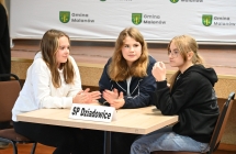 Trzy dziewczynki siedzące przy stoliku 