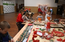 Grupa dzieci i zdobiących pierniczki na sali centrum kultury. 