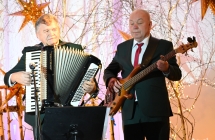 Dwoje mężczyzn z zespołu ludowego - jeden gra na akordeonie drugi na gitarze elektrycznej 