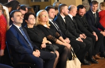 Elegancko ubrane kobiety oraz mężczyźni oglądający koncert bożonarodzeniowy 