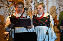 Dwie kobiety w charakterystycznych strojach ludowych śpiewające piosenki 