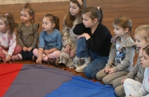 Dzieci siedzące przy chuście edukacyjnej 