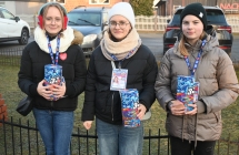 Trzy dziewczynki - wolontariuszki zbierające pieniądze przy kościele 