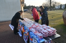 Kobieta i mężczyzna obsługujący panią podczas kiermaszu ciast przy kościele 