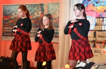 Trzy dziewczynki w jednakowych strojach wykonujące układ taneczny 