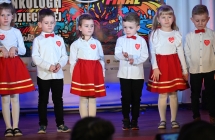 Kilkoro dzieci w zgranych strojach na scenie