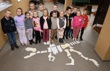 Dzieci przy tekturowym szkielecie dinozaura