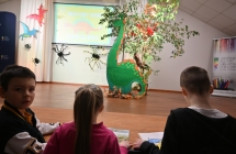 Troje dzieci oglądających film o dinozaurach 