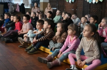 Grupa dzieci oglądających film o dinozaurach 