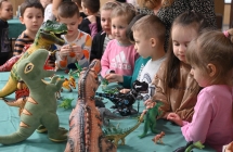 Przedszkolaki oglądające zabawki dinozaurów 