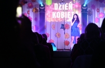 Kobieta w eleganckiej sukni śpiewająca na scenie 