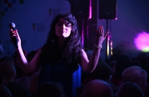 Kobieta z rozmarzoną miną śpiewająca na scenie 