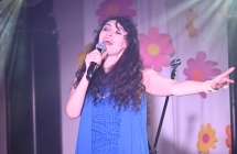 Kobieta śpiewająca do mikrofonu na scenie 