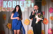 Kobieta i mężczyzna na scenie. Mężczyzna w dłoniach trzyma bukiet kwiatów 