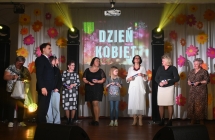 Mężczyzna mówiący do mikrofonu. Obok niego kilka kobiet 