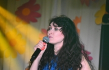 Elegancko ubrana kobieta na scenie. Śpiewa do mikrofonu 