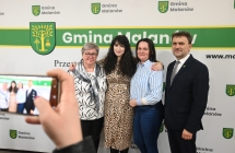 Artystka razem z fanami na tle ścianki z napisem - gmina malanów 