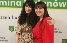 Dwie uśmiechnięte kobiety pozujące do wspólnego zdjęcia na tle ścianki z napisem - gmina malanów 