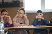 Troje dzieci siedzących przy ławce 