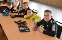 Kilkoro chłopców siedzących przy ławce 