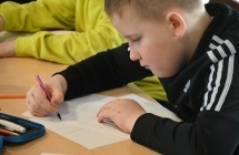 Chłopiec skupiony na rysowaniu komiksu 